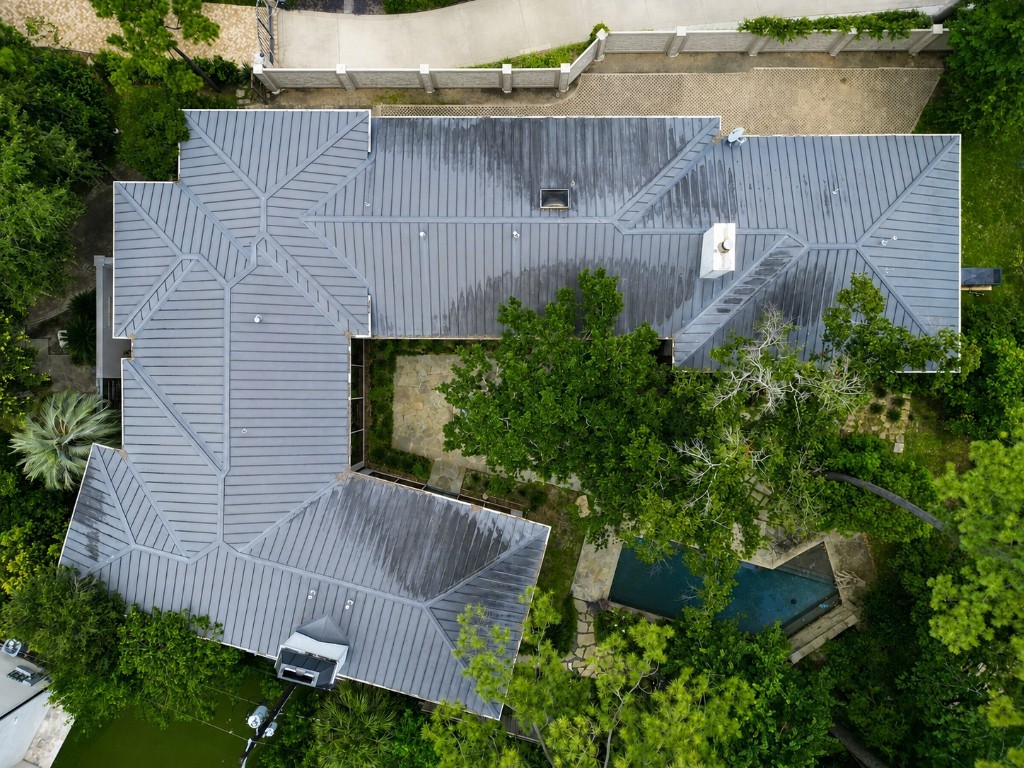 Standing-seam metal roof with organic streaking before soft washing